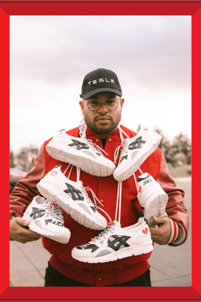 artist holding several pairs of sneakers