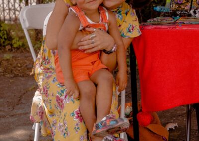 Vendor smiling with a child at her table